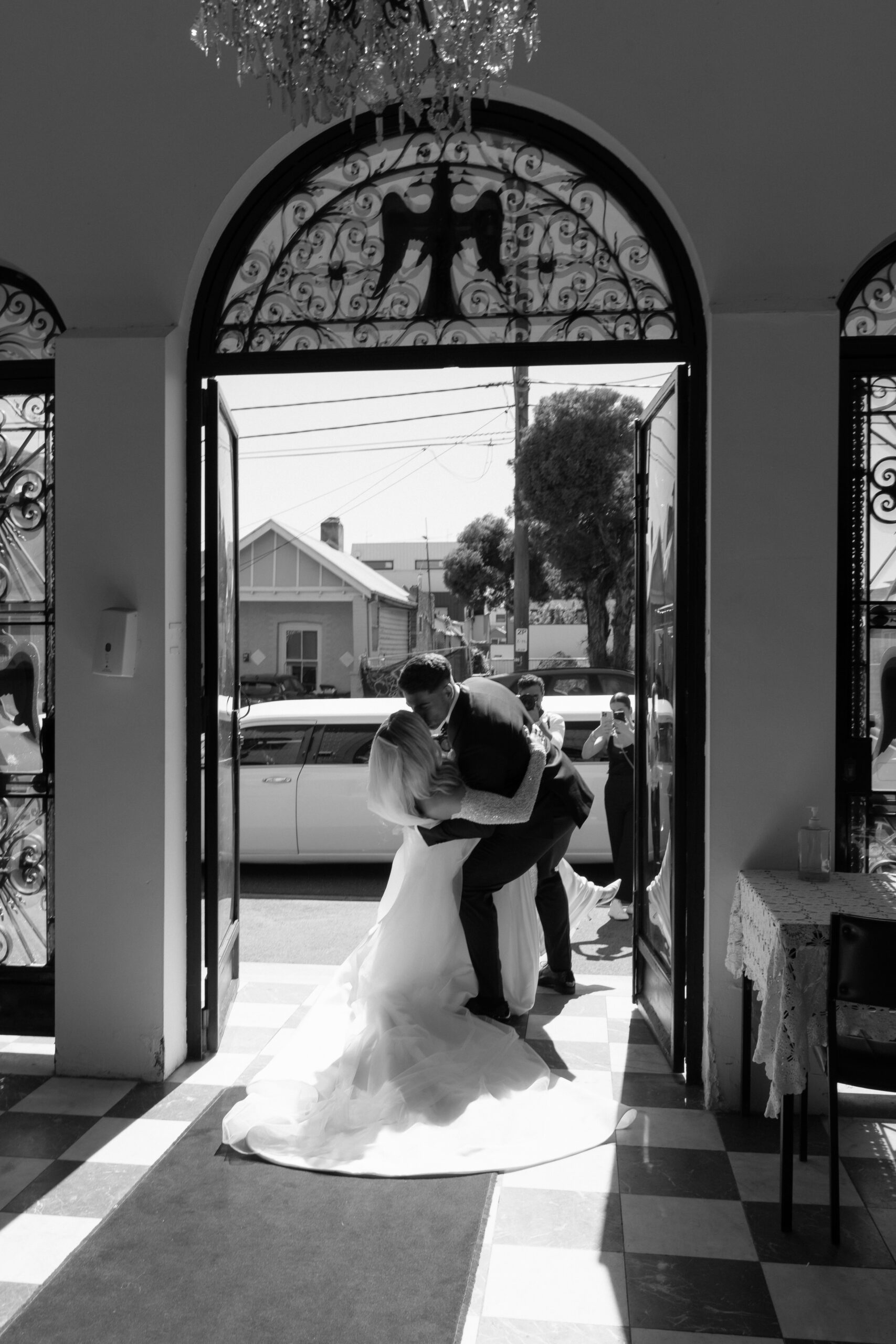Bride and groom kissing as they exit the church