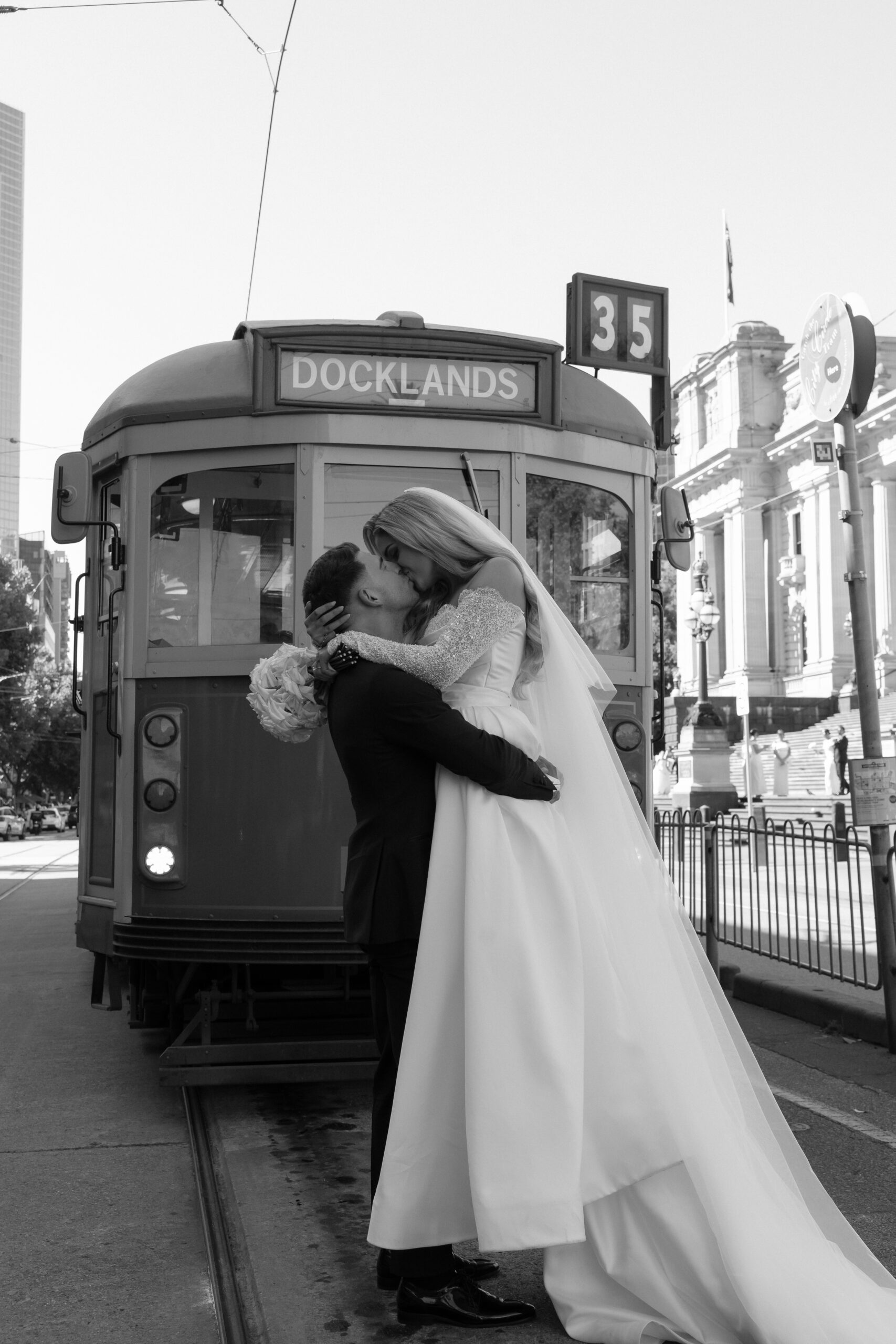 Bride and groom kissing in front of a melbourne tram.
