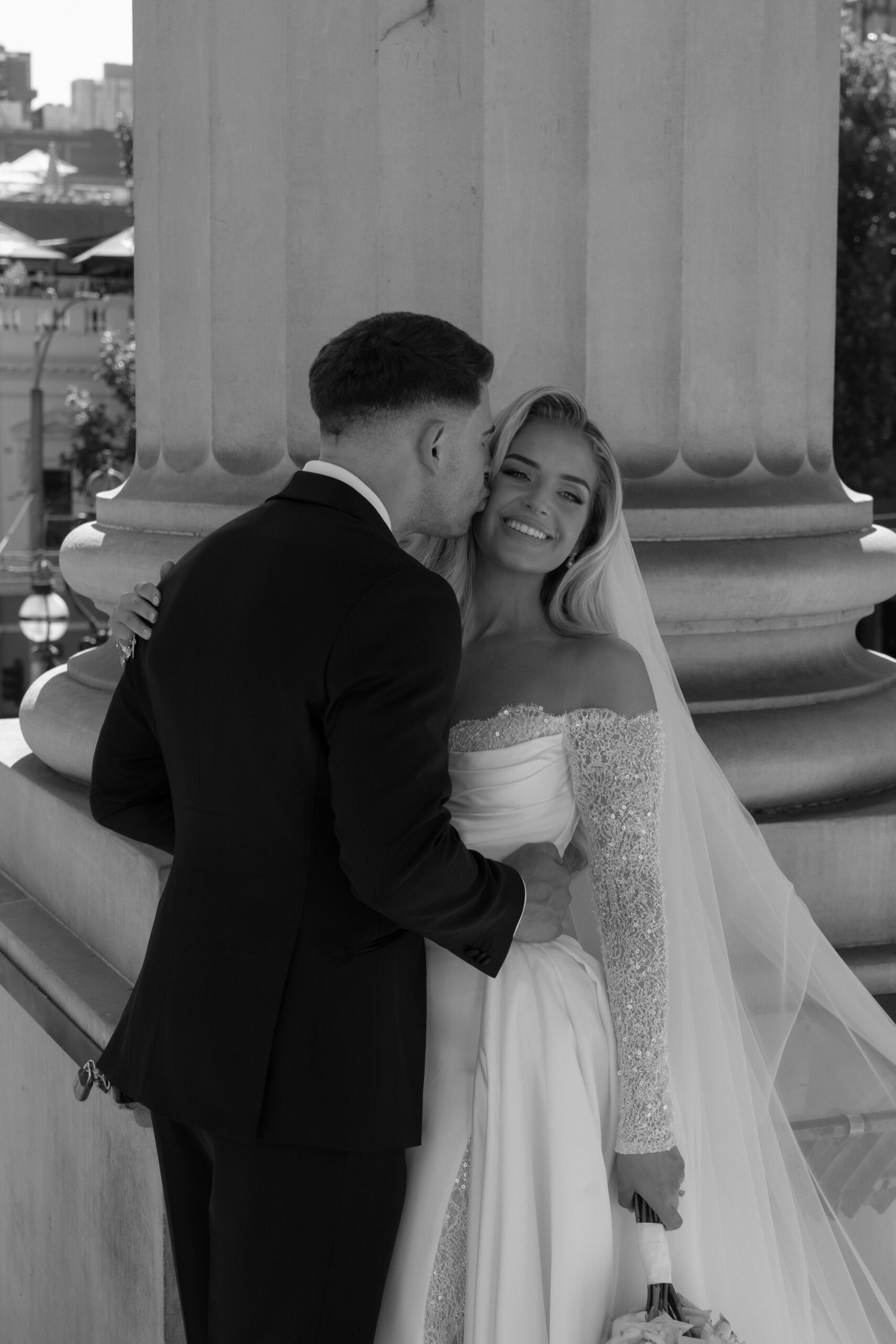 Groom kissing his bride on the cheek.