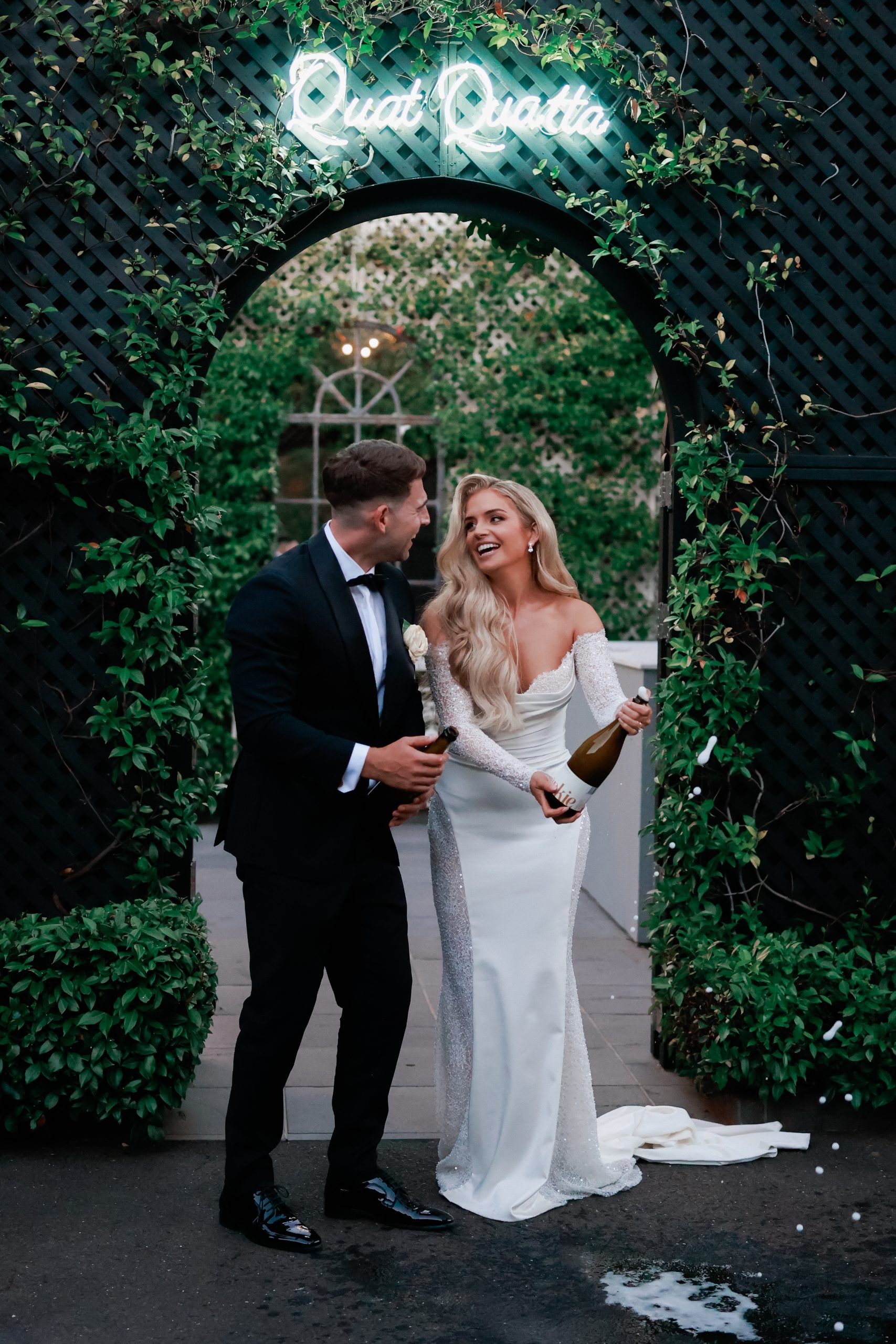 Bride and groom popping bottle of champagne at their wedding ceremony. 