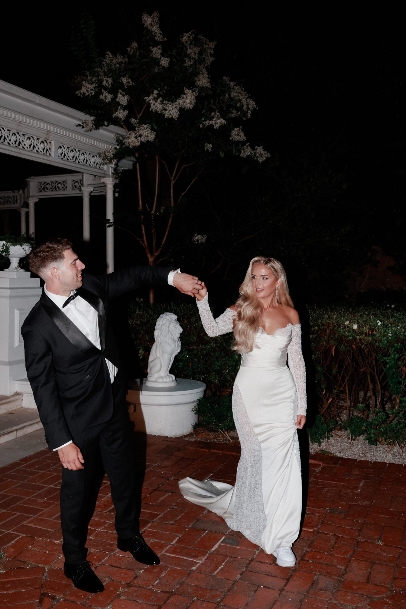 Bride and groom at their wedding celebration, groom about to twirl bride. 