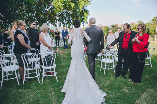 bride walking down aisle with long train wedding dress photo
