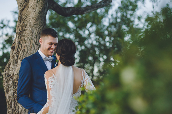off the shoulder lace wedding dress with long plain veil low bun