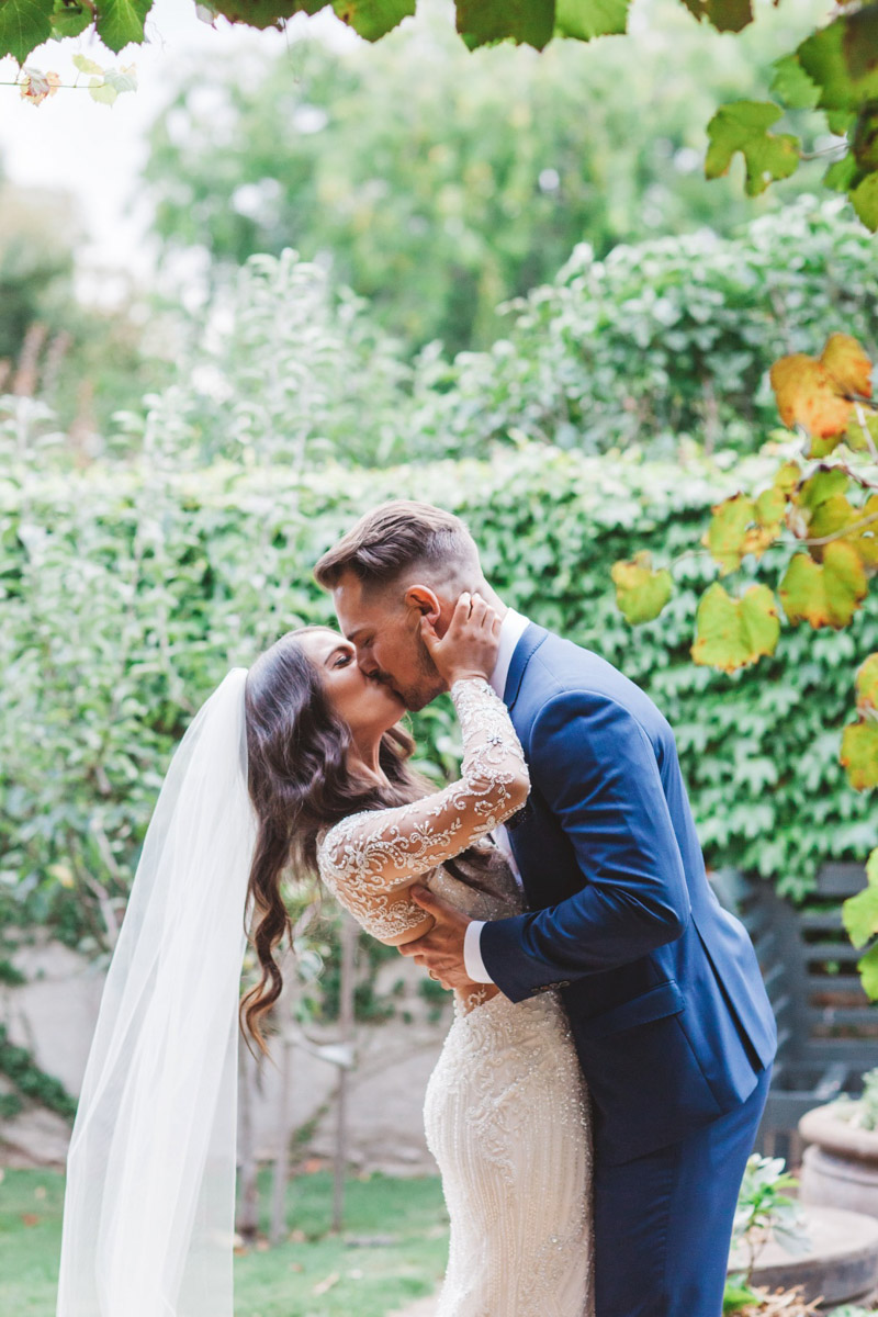 bride and groom kissing - Real bride wears Demetrios Platinum 330 wedding dress
