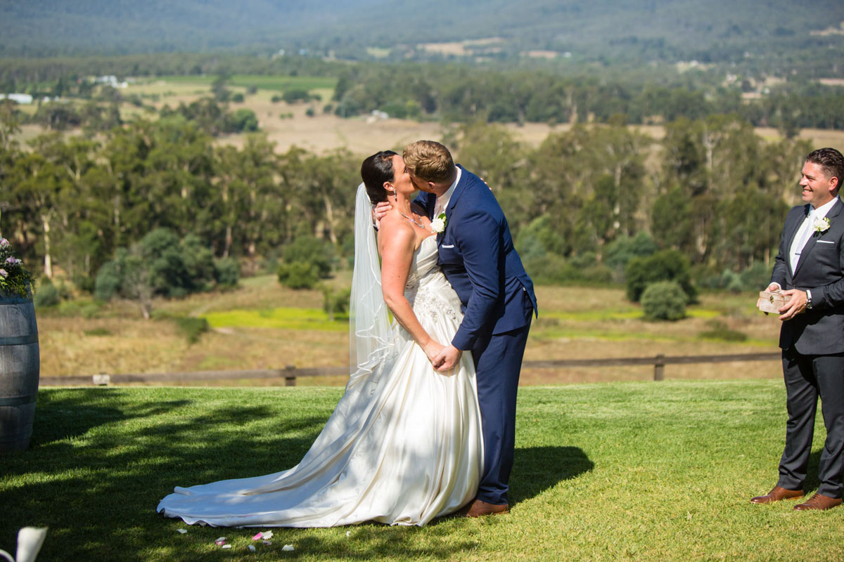 Photo of a bride and groom kissing aisle