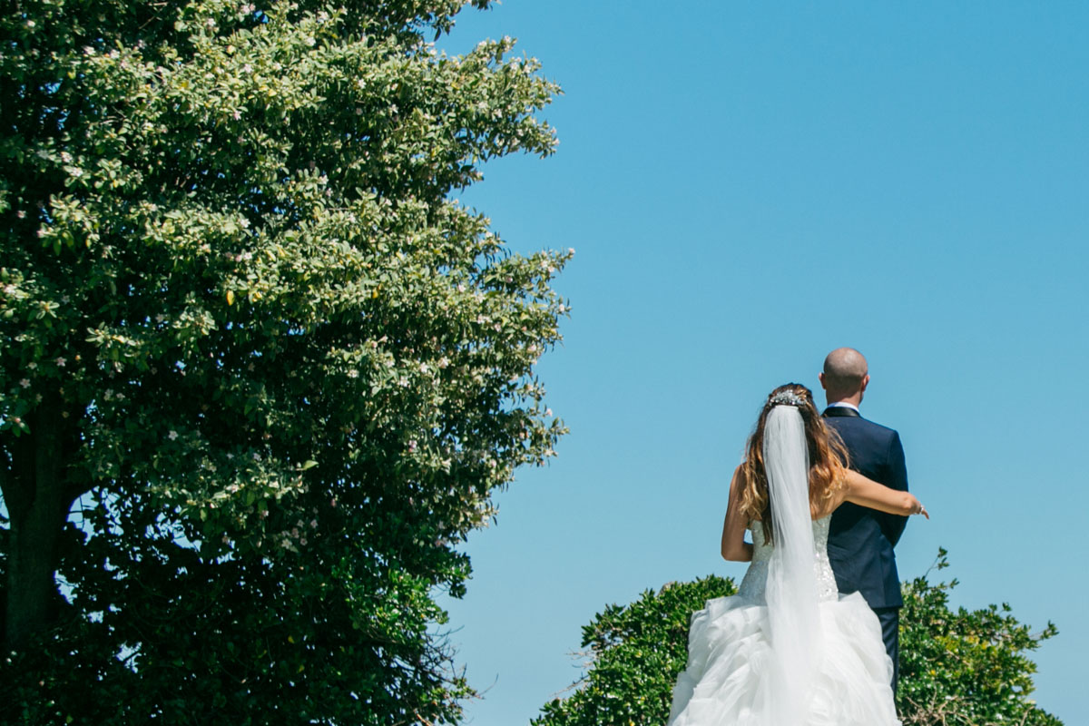 bride and groom walking photo against blue sky