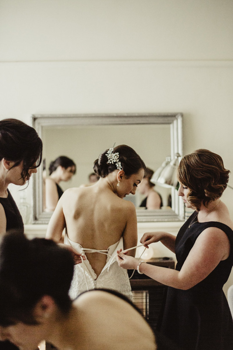 bridesmaids helping bride get ready photo